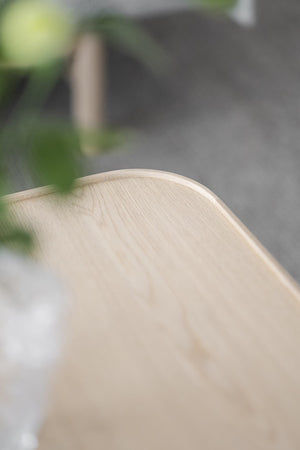 Ljust träbord med naturlig trästruktur och rundad kant i närbild