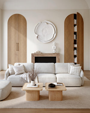 Modernt vardagsrum med beige soffa, trämöbler med räfflad design och ljusa naturfärger i skandinavisk stil