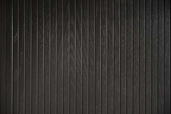 Svart träpanel med vertikal ribbad struktur och synlig träådringsmönster