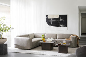 Grå modulsoffa med schäslong i modernt vardagsrum med abstrakt konst och mörka soffbord