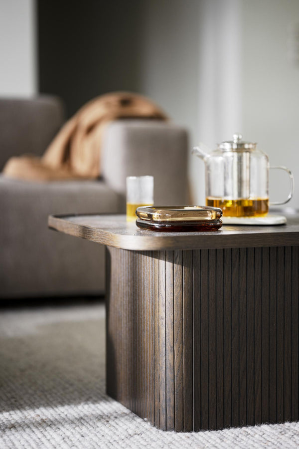 Soffbord i trä med honung, tepanna och kopp i modern skandinavisk inredning