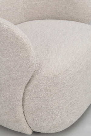 Närbild på beige puff eller sittpuff med mjuk boucléklädsel och rundad, organisk form