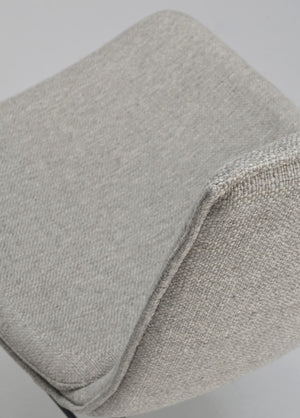 Närbild på ljusgrå textil med synlig vävstruktur och mjuk vikning som visar materialets kvalitet