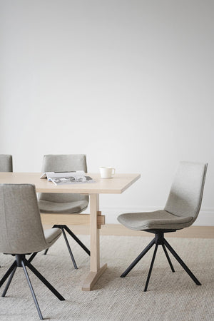 Matbord i ljust trä med grå stolar och svarta ben, modern skandinavisk design för matrum