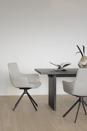 Grå matstolar med svart spindelben vid matbord i modern skandinavisk design