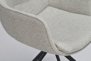 Närbild på stol med ljusgrå klädsel och svarta ben, detalj av sits och armstöd