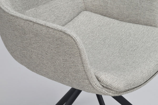 Närbild på stol med ljusgrå klädsel och svarta ben, detalj av sits och armstöd