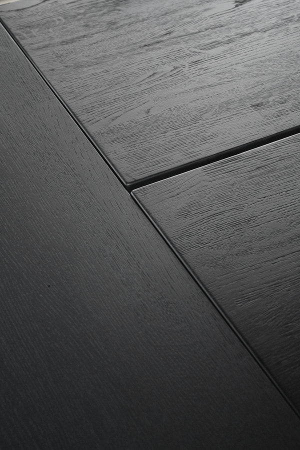 Mörkgrå träbord med synlig trästruktur och elegant skarvfog mellan bordsskivor