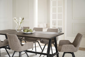 Matgrupp med grå stoppade stolar och bord i mörkt trä med svarta ben i ljus matsal