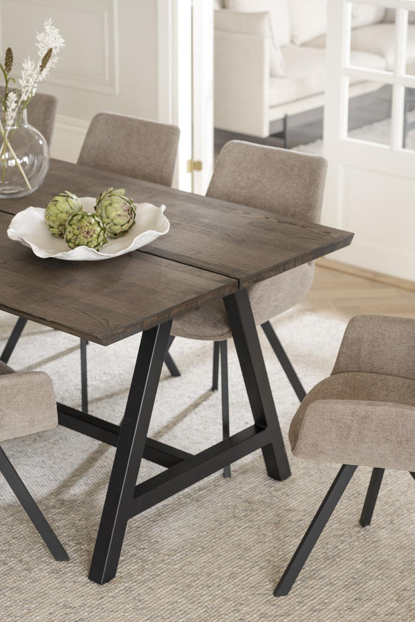 Matbord i mörkt trä med svarta A-formade ben och gråbeige stoppade stolar i modern matsal