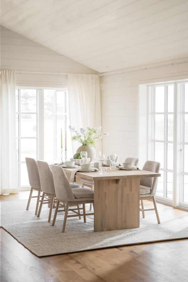 Ljus matplats med träbord, beige stolar och vita väggar i skandinavisk stil