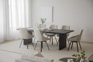 Matbord i mörkt trä med beige stoppade stolar i modern matsal med ljust inredning