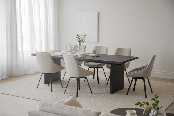 Matbord i mörkt trä med beige stoppade stolar i modern matsal med ljust inredning