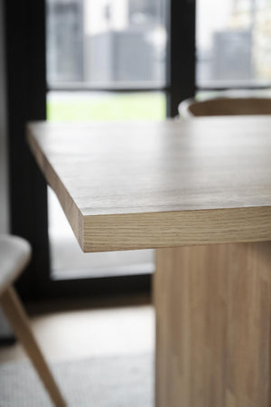 Närbild på skrivbordskant i ljus ek med synlig trästruktur och vinkelslipade kanter