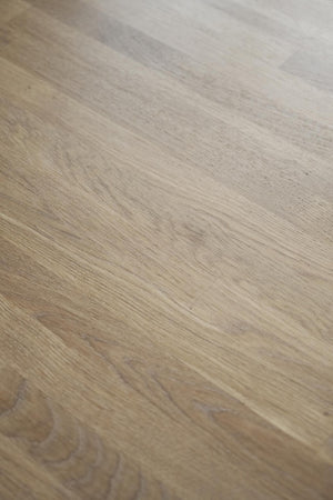 Ljust trägolv med naturlig ekstruktur och synliga årsringar i diagonal vinkel