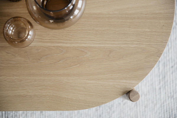 Runt soffbord i ljust trä med glasvasar, designmöbel för vardagsrum