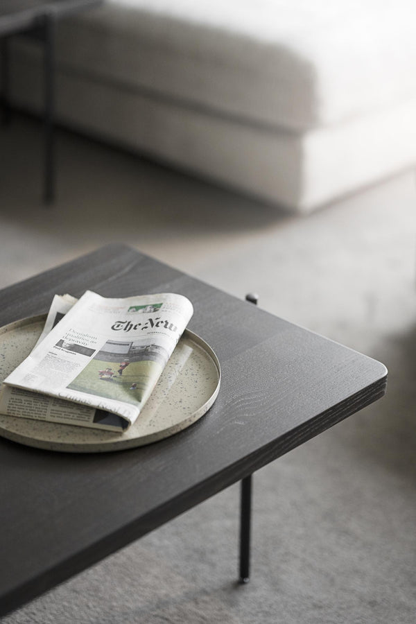 Soffbord i grå ek med spräcklig keramikfat och tidning, minimalistisk skandinavisk inredning