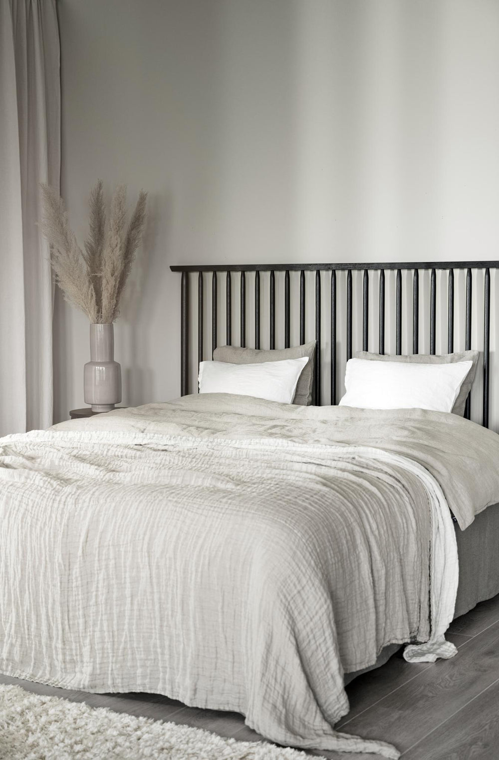 Svart balkongräcke med vertikala spjälor och grå handledare i modern design