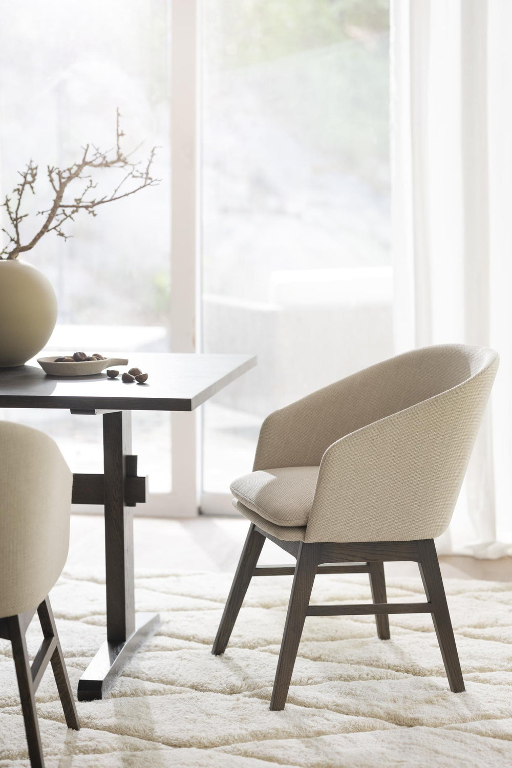 Beige stoppad matstol med träben i mörk ek, modern skandinavisk design