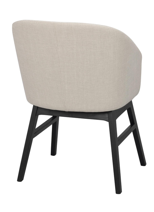 Beige fåtölj med svarta träben, rund rygg och modern design, snett bakifrån
