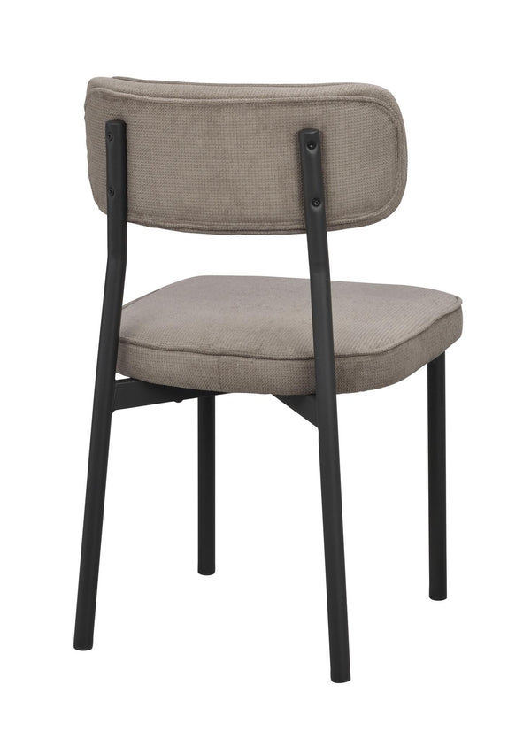 Stoppad matstol med beige klädsel och svarta metallben, sedd bakifrån