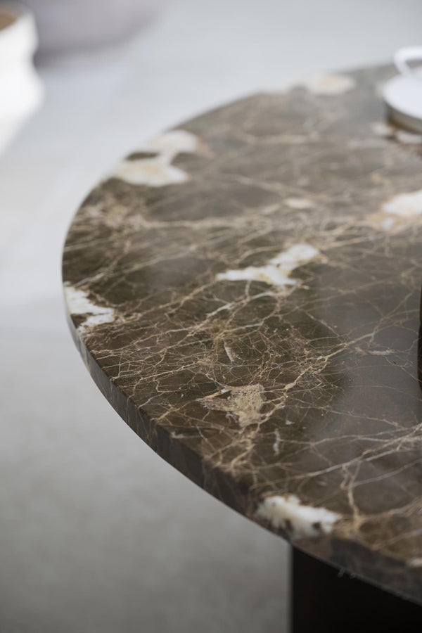 Bord med brun marmorskiva och vita ådror i närbild, elegant naturstensyta för inredning
