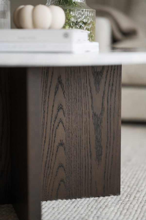 Soffbord med mörkbrun ekfaner och vit marmorskiva, visande träets naturliga ådringsmönster