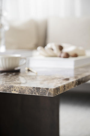 Marmorbord med dekorativa föremål och neutral inredning i beige och bruna toner