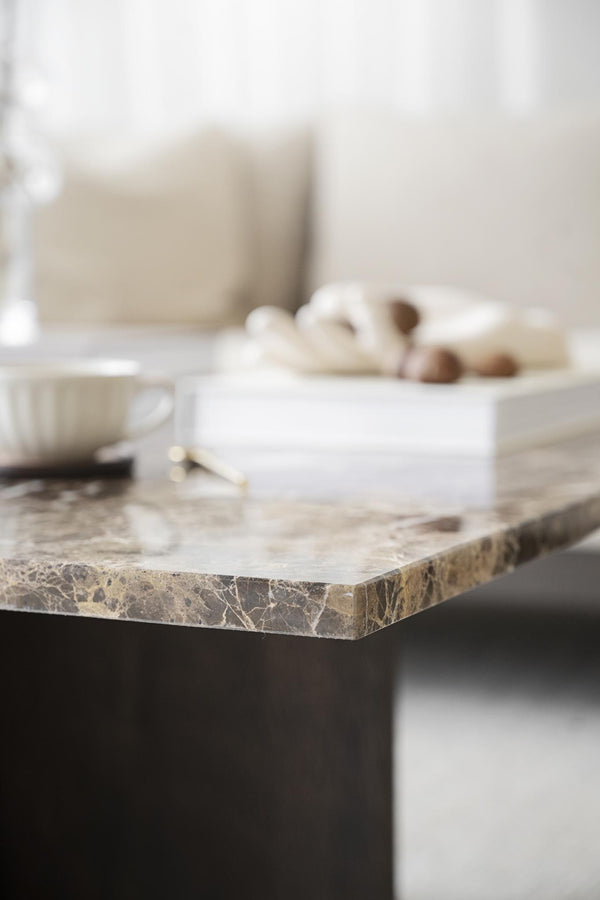 Marmorbord med dekorativa föremål och neutral inredning i beige och bruna toner