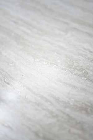 Närbild av vit marmor med grå ådring och naturlig stenmönster, lämplig för bänkskiva eller kakel