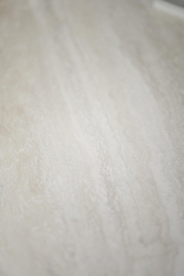 Vit marmorbänkskiva med naturliga grå ådror och blank yta i närbild