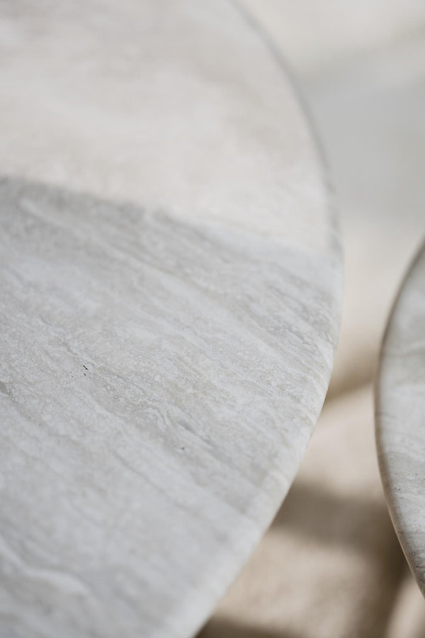 Närbild på grå trästockar med naturlig struktur och textur, staplade i varmt ljus