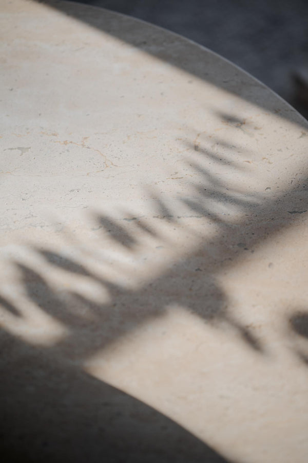 Detaljbild av präglad text eller logotyp på ljus betongyta med skuggor