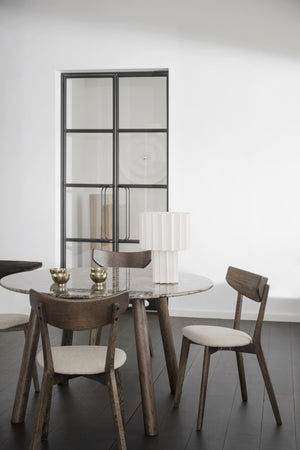 Runt matbord i marmor med träben och stolar i skandinavisk design, vit skulptur och glaskåpa som dekoration