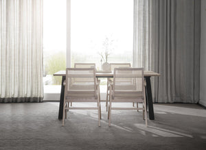 Matgrupp med ljust trä och rotting i minimalistisk matsal med stora fönster och gardinuppsättning