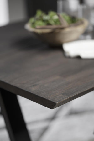 Närbildsbild av mörkt träbordsskiva med träådring och matt yta i modern skandinavisk stil