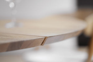 Närbild på träskiva med synlig spricka eller fogning i ljust trä, ofokuserad bakgrund