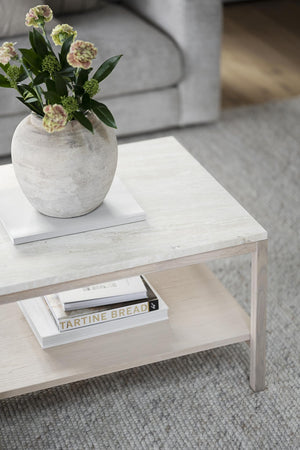 Soffbord i ljust trä med hylla, dekorerat med vas och böcker på ljus matta i vardagsrum