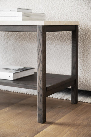 Soffbord i mörkbejsat trä med hylla, dekorerat med böcker på ljus matta och parkettgolv