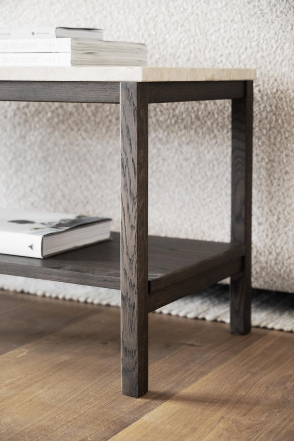 Soffbord i mörkbejsat trä med hylla, dekorerat med böcker på ljus matta och parkettgolv