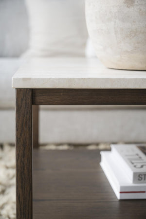 Soffbord med vit marmorskiva och mörkbruna träben, skandinavisk design med bok på hylla
