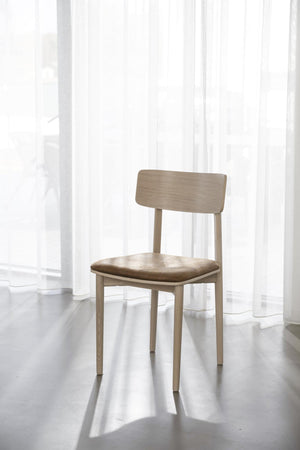 Ljus trästol med stoppad sits i beige tyg, skandinavisk design med raka ben och låg rygg