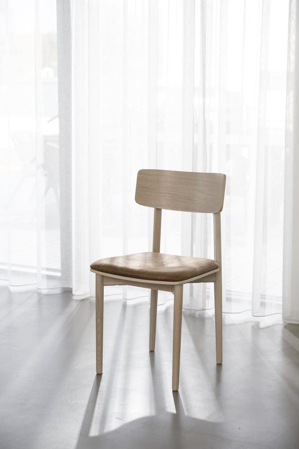 Ljus trästol med stoppad sits i beige tyg, skandinavisk design med raka ben och låg rygg