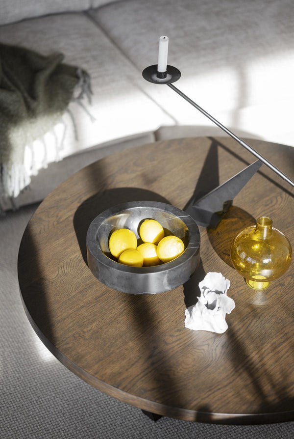 Runt soffbord i trä med skål, ljusstake och dekorativa detaljer i skandinavisk stil