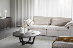 Beige soffa med soffbord i modern skandinavisk vardagsrumsinredning med vita gardiner och minimalistisk design