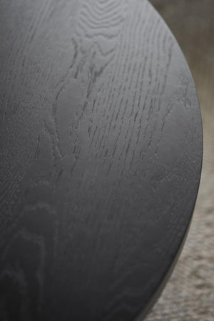 Närbild av svart träskiva med synlig trästruktur och matt yta