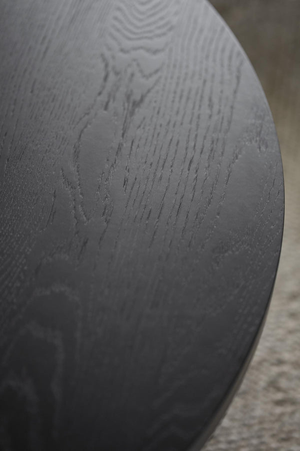 Närbild av svart träskiva med synlig trästruktur och matt yta