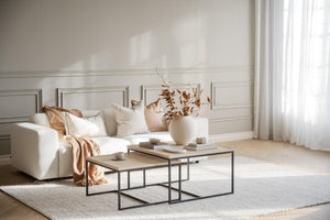 Soffbord i industriell stil med svart metallstativ och ljust trä, dekorerat med vas och böcker i ljust vardagsrum