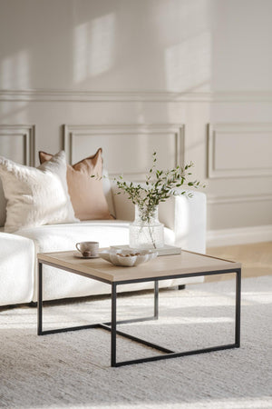 Soffbord i ljust trä med svart metallram, dekorerat med vas, kopp och skål i ljust vardagsrum