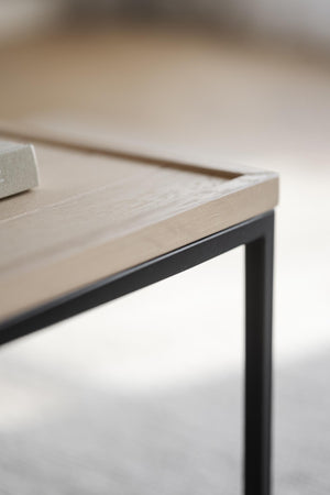 Närbild på soffbord med ljus träskiva och svart metallram i modern skandinavisk design